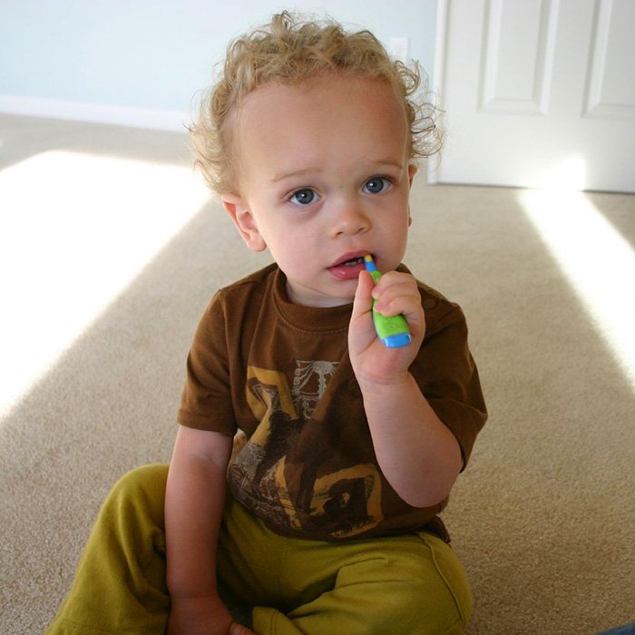 White toddler boy brushing his teeth.