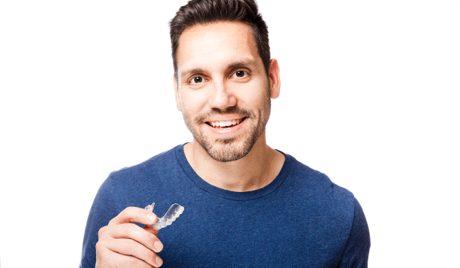 man holding invisalign aligner