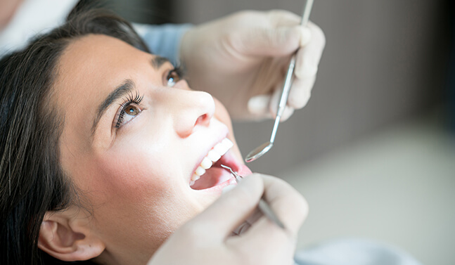 woman having her teeth examined by her dentist