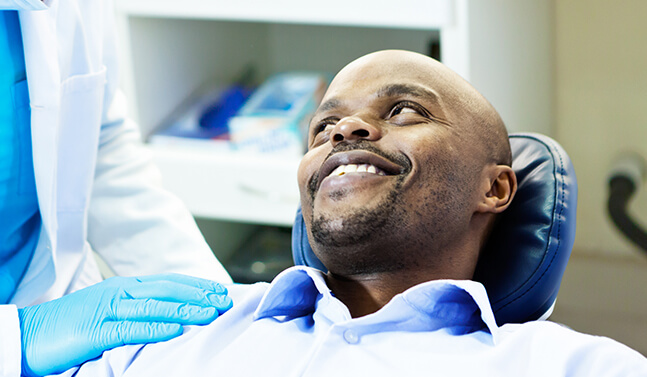 smiling man being comforted by his dentist