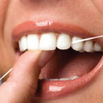 close up of a woman flossing her teeth