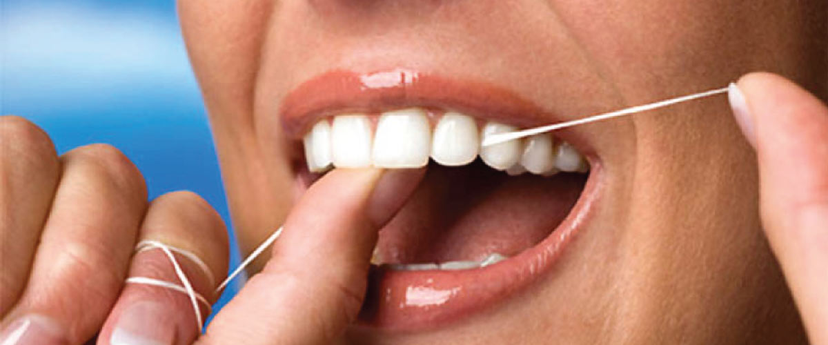 close up of a woman flossing her teeth