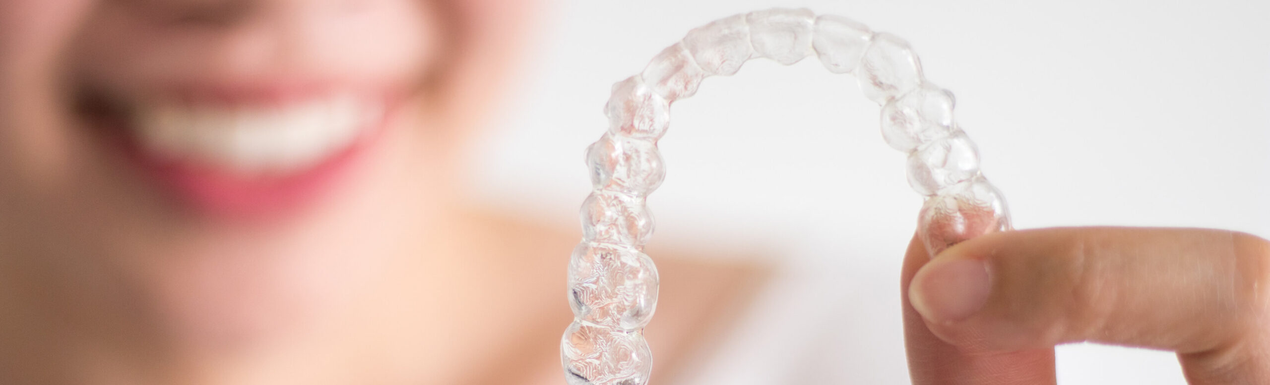 closeup of a person holding a clear aligner