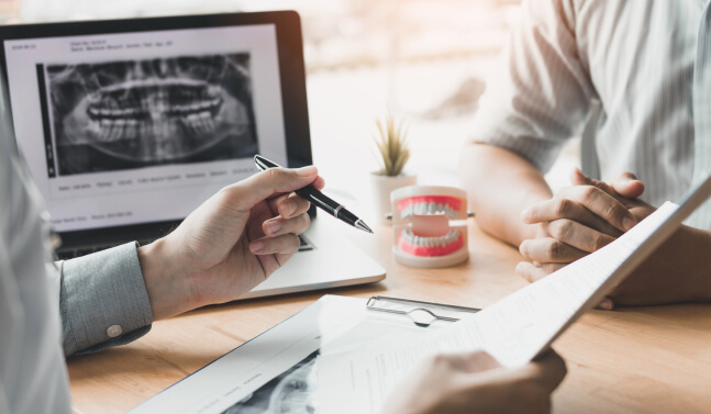 two people discussing dental-related paperwork