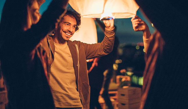 man lighting a lantern