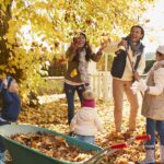 family playing in the leaves before fall dental checkup